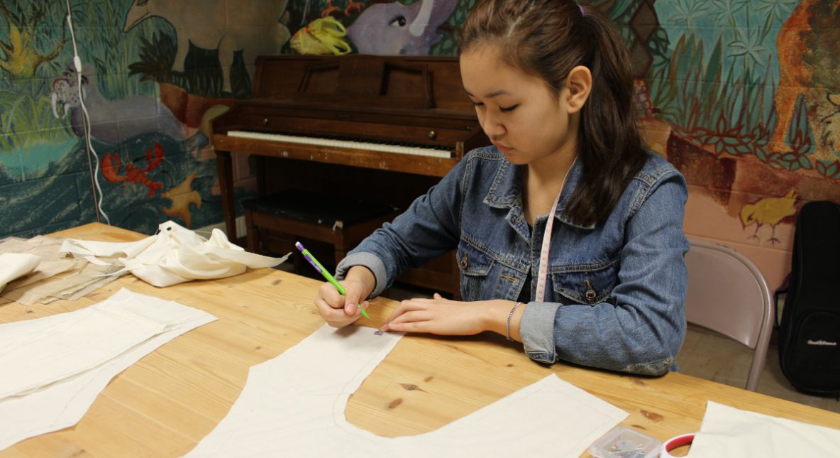 Teen drawing on a hand-made pattern