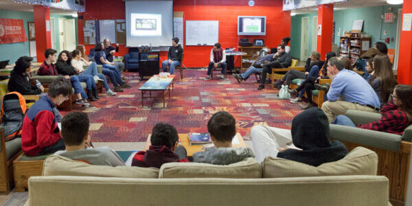 Youth and staff of Princeton Learning Cooperative circled up for all-group meeting in the Common Room